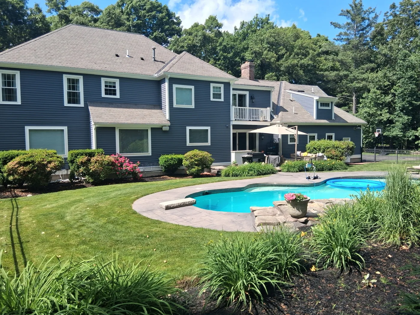 Painted gray-blue home seen from the pool area