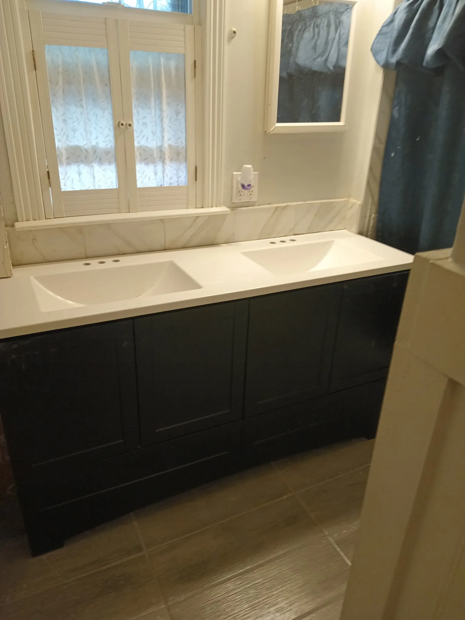 Painted dark bathroom vanity with white countertop and trim