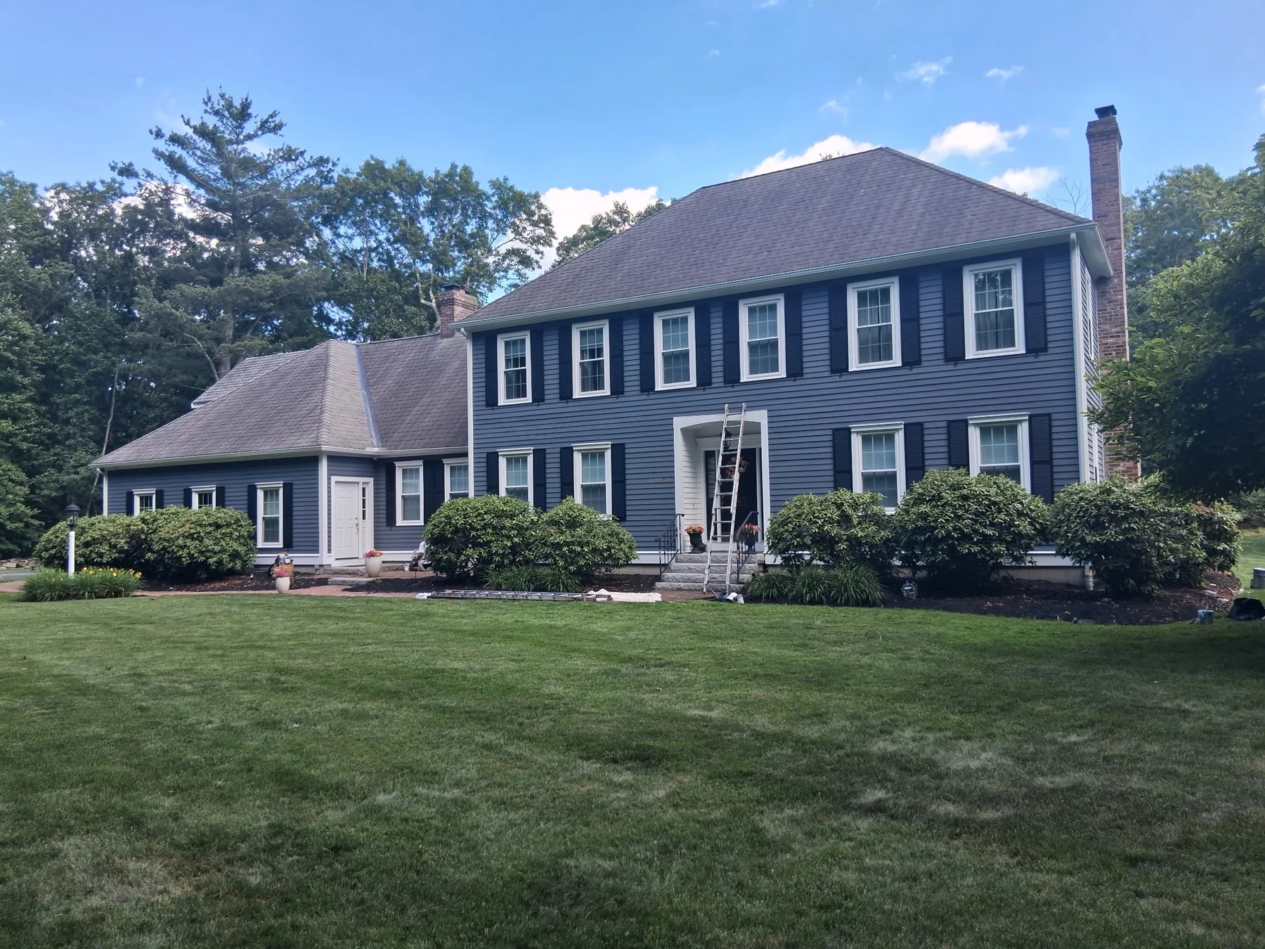 Finished two-story blue-gray home with white trim and black shutters